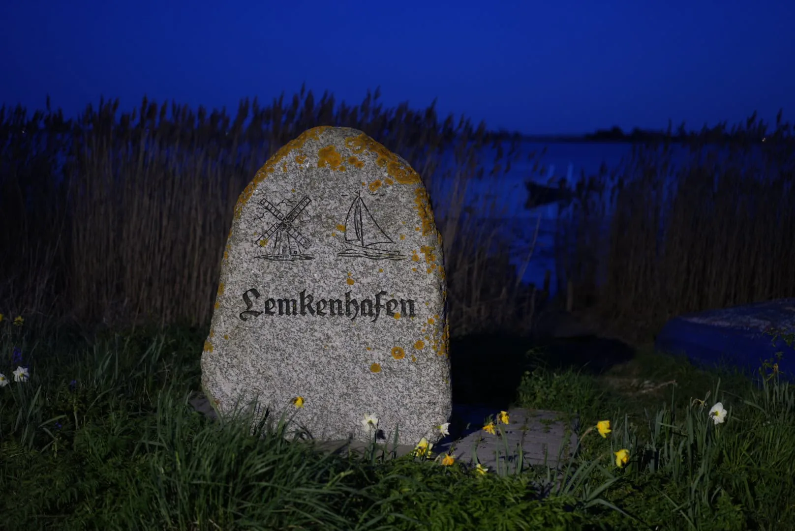 Historischer Ortsstein von Lemkenhafen in der blauen Stunde